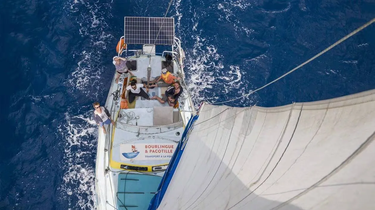 Vue aérienne d’un voilier-cargo en mer, l’équipage sur le pont