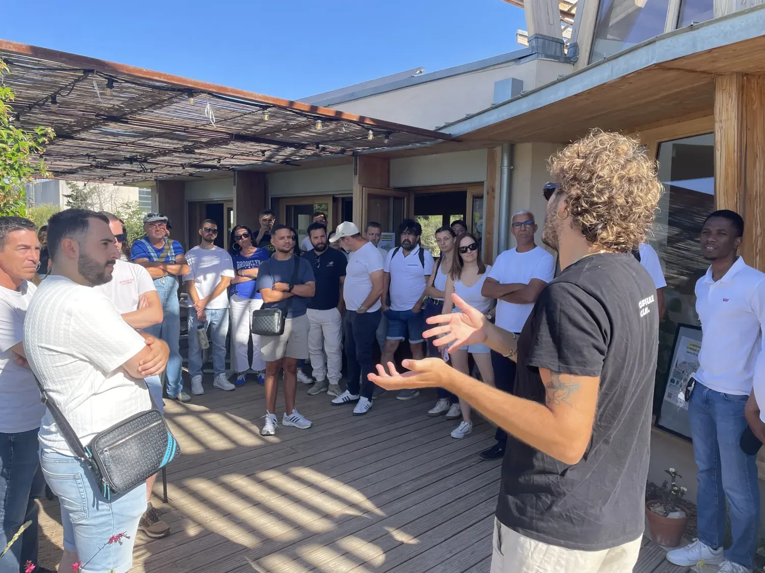 Felix Wauquiez échange avec un groupe sur une terrasse en bois